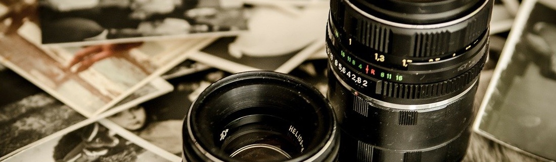 Na stole ležící fotografie s objektivem fotoparátu